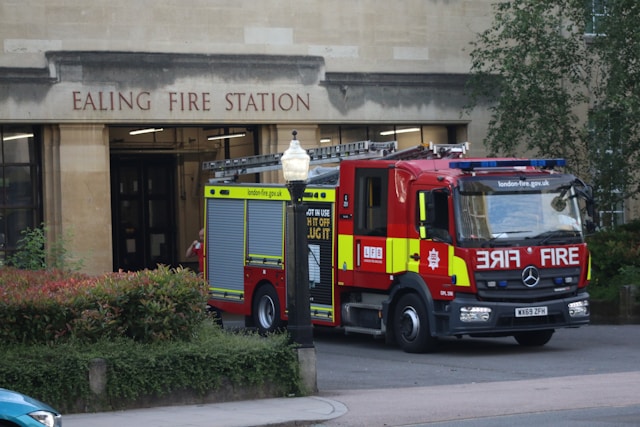 Red & yellow fire engine outside Ealing Fire Station in London : Fire Risk Assessments.